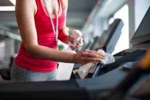 spraying cleaning gym wipe