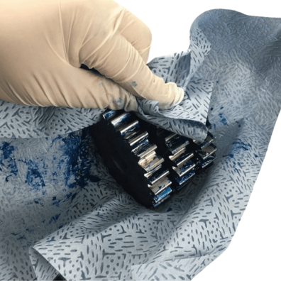 Industrial nonwoven wipe cleaning a metal gear